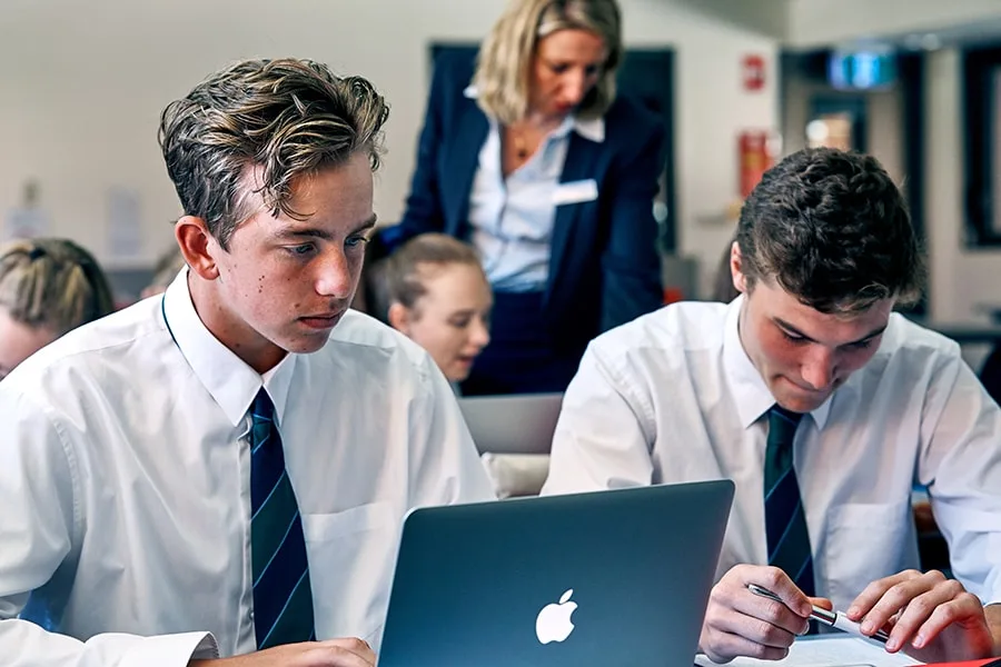 two schooboys sitting next to each other