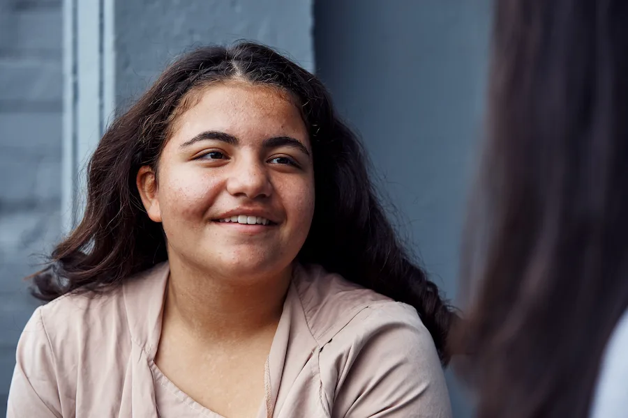 young person smiling to the left