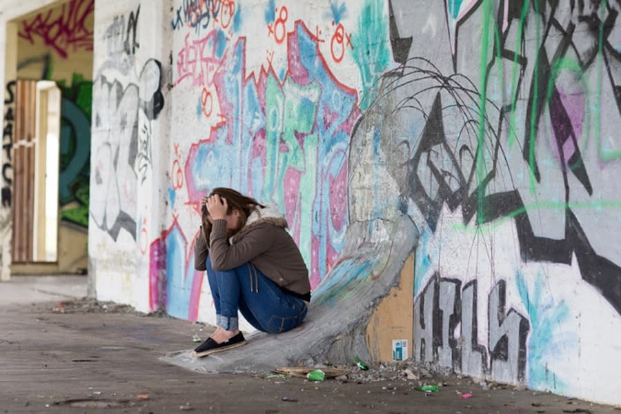 Girl with her head in her hands on the street