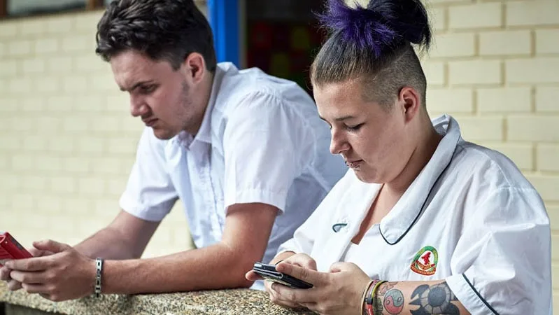 boy and girl using mobile phones