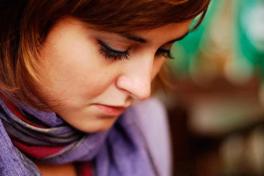 sad girl with red hair and purple scarf