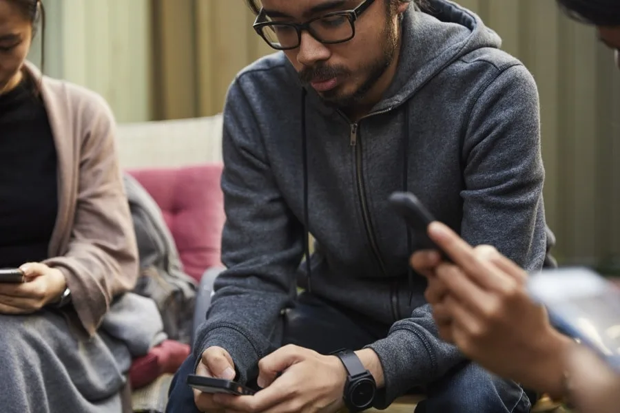 young man at party looking at phone