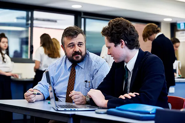 Teacher sitting down with student