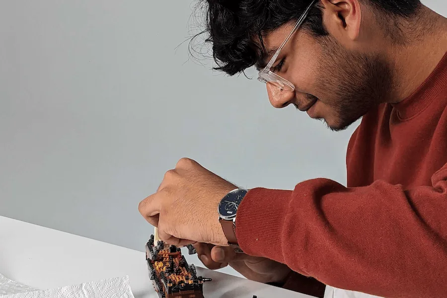 Side profile image of Azhaan, who is smiling as he builds a lego pirate ship.