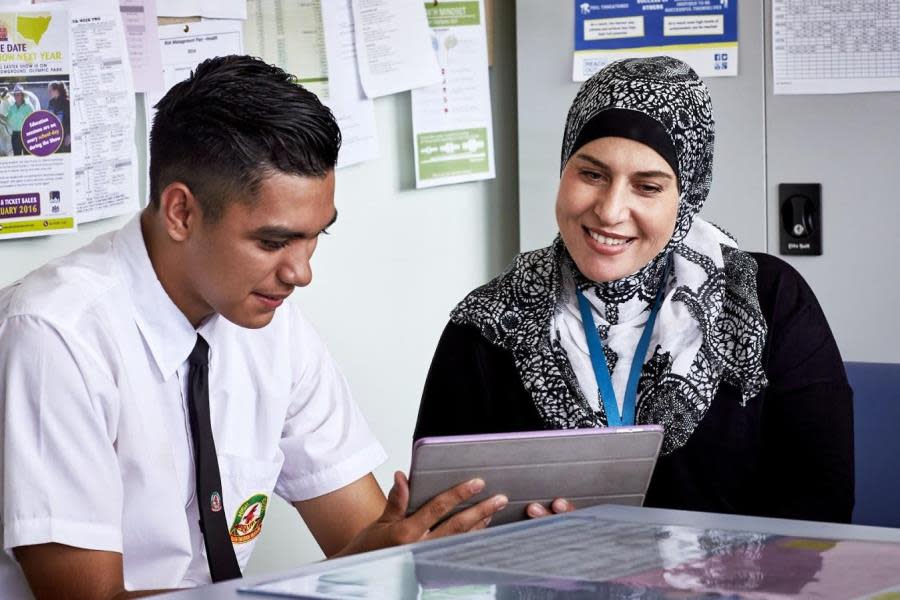 social worker staring at tablet with young person