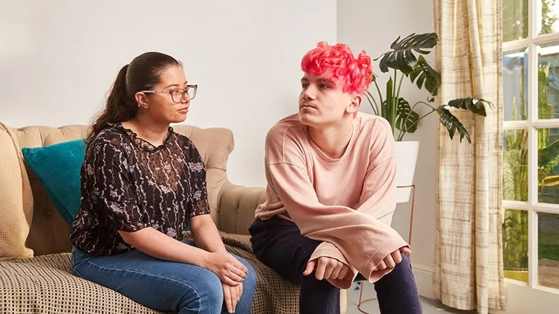 teenage boy and girl sitting on the couch together