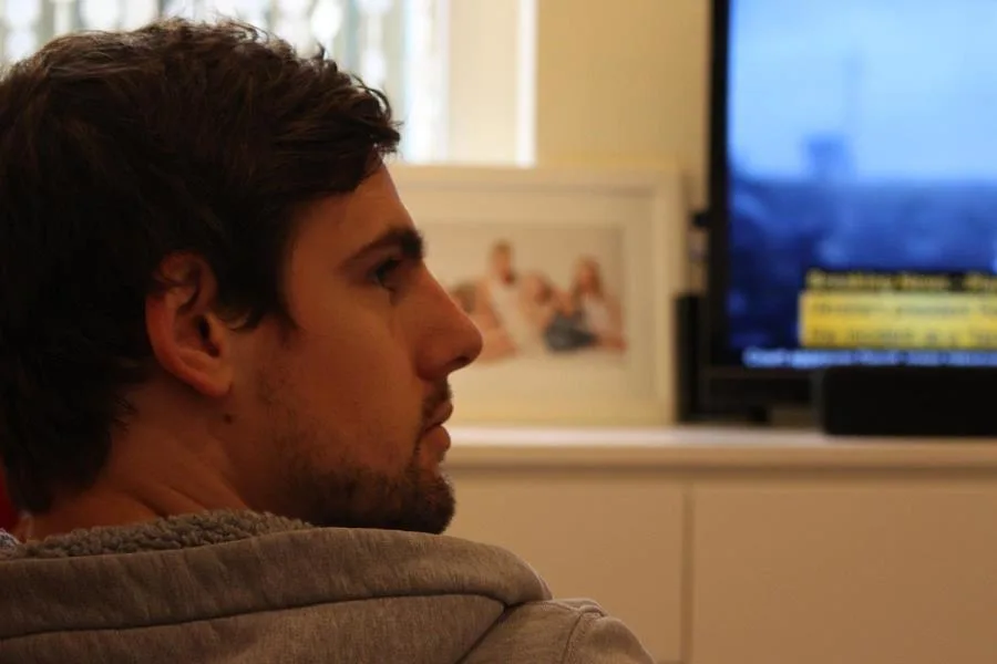 Boy looking to the side on front of TV