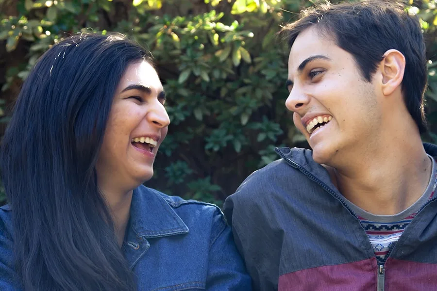 Close up of girl and guy looking at each other and laughing