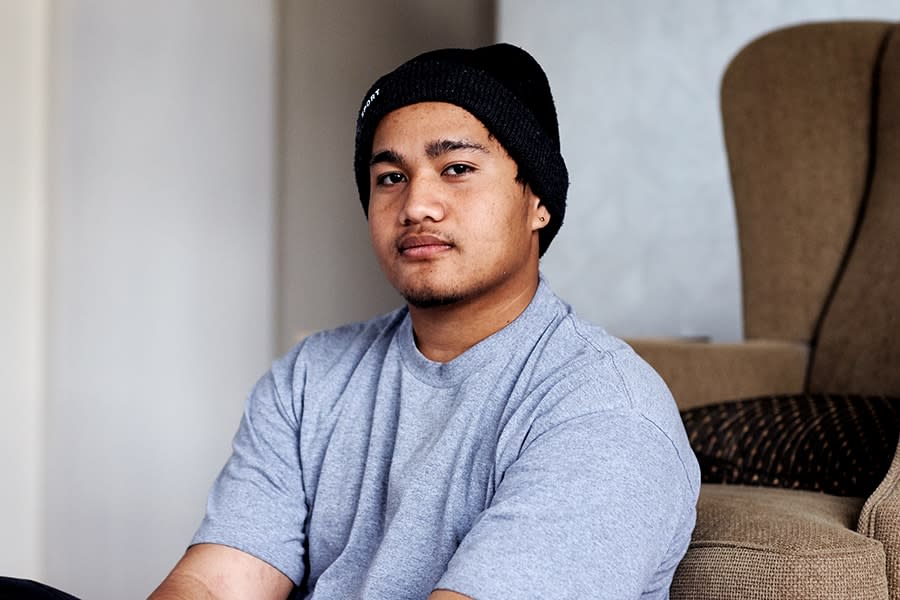 young male wearing beanie sitting against couch