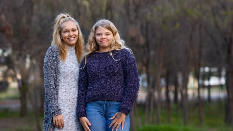 indigenous mum standing with her teen daughter outside