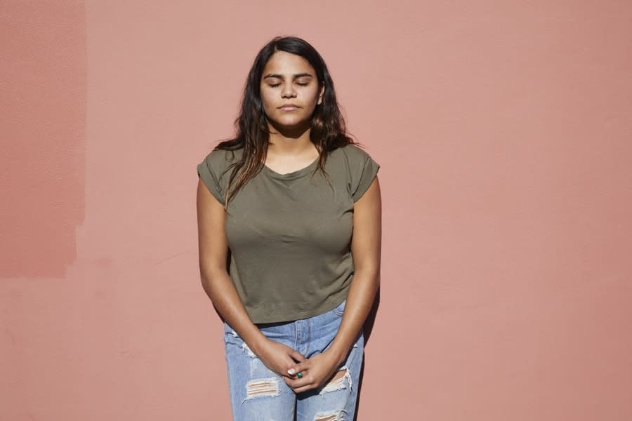 girl leaning against wall with eyes closed