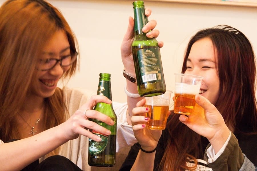 Beer bottles and plastic cups full of beer in toast