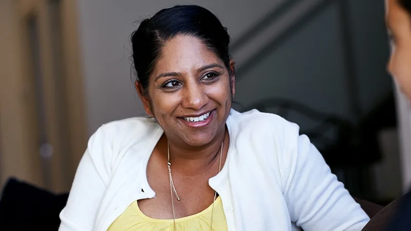 woman sitting on couch smiling at son