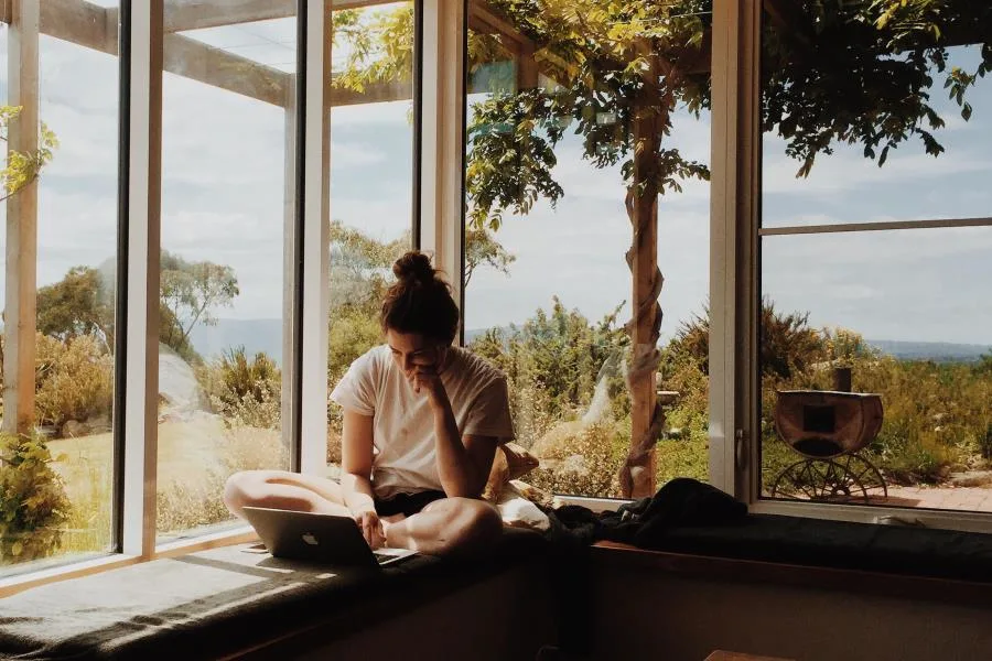 Girl sitting at window with laptop