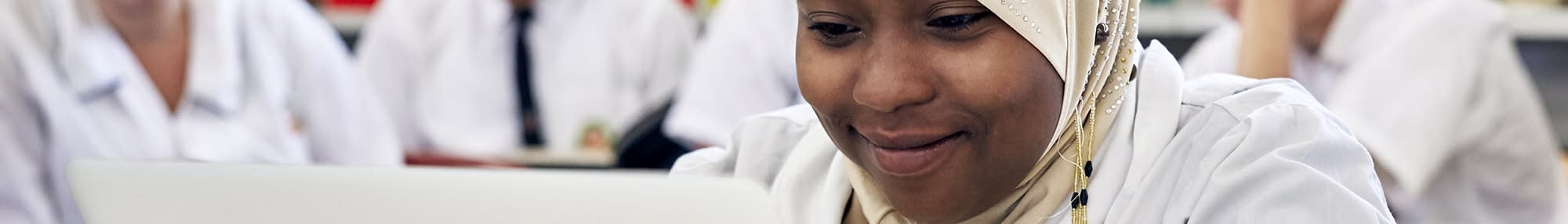 student uses laptop in classroom