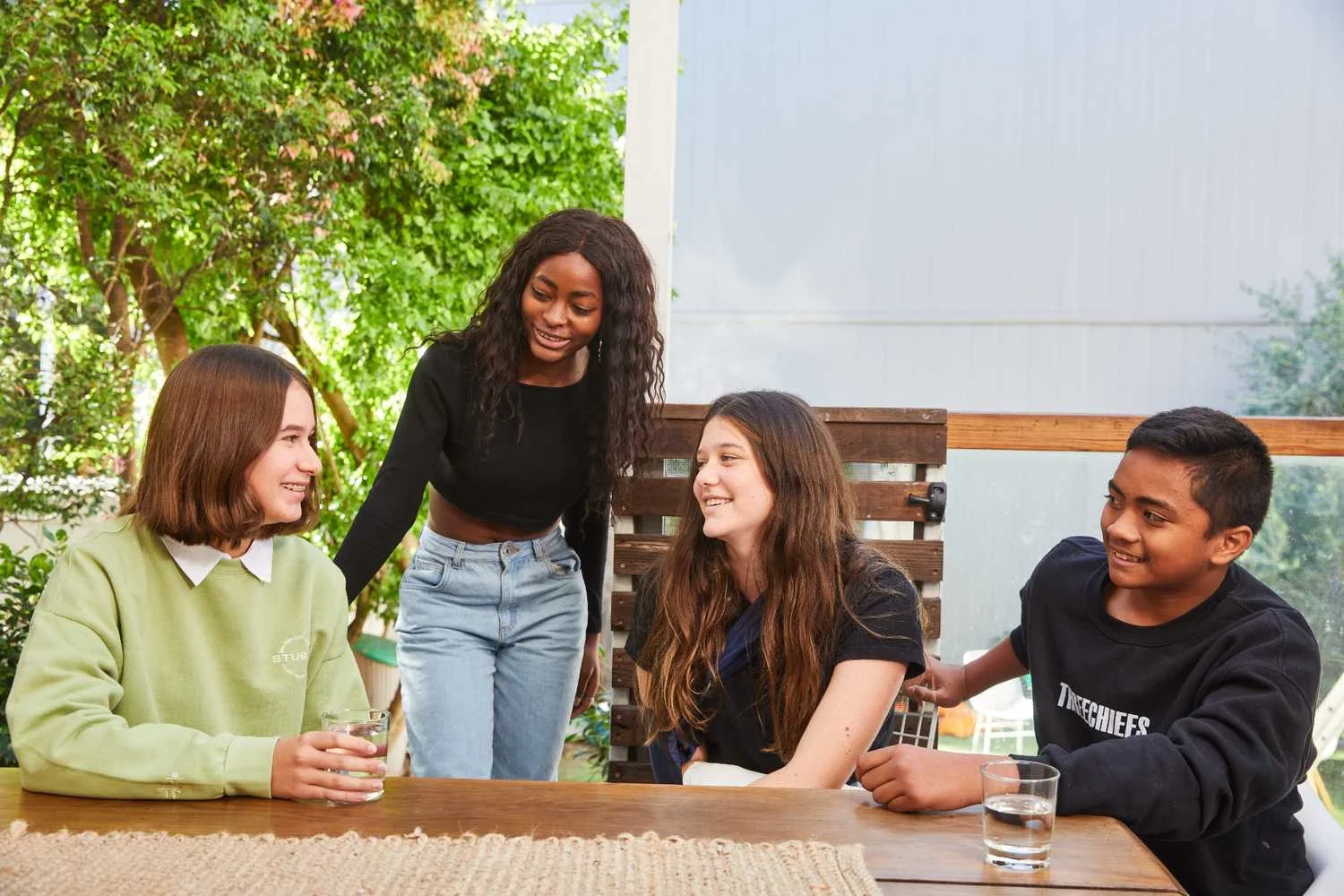 Young people talking and laughing around table