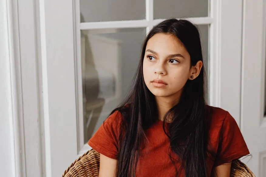 Teen girl sitting lost in thought
