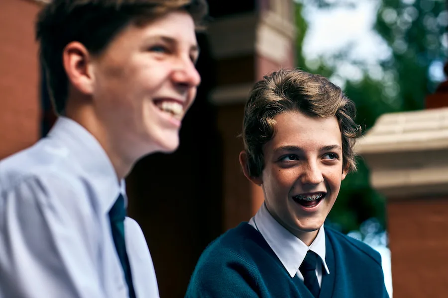 Two students laughing and looking away from camera