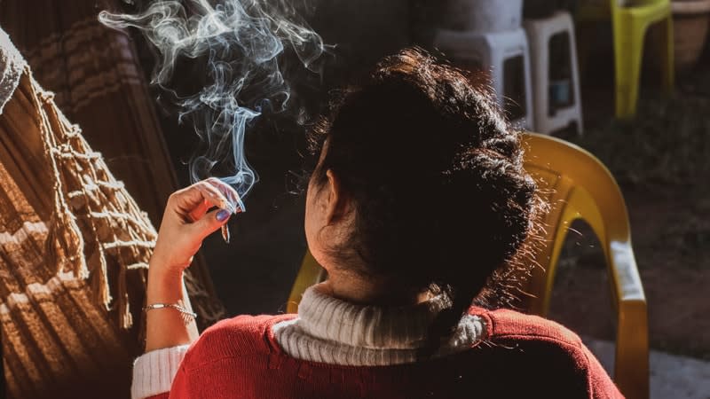 Girl smoking cigarette with cloud of smoke around her head
