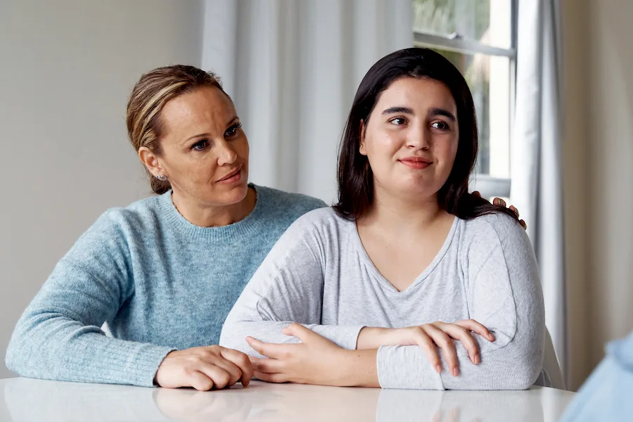 Mother and daughter sitting down listening