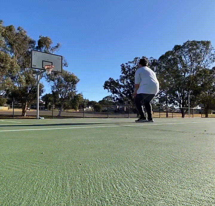 A GIF of Dom, the author, shooting a basketball into a hoop in a park.