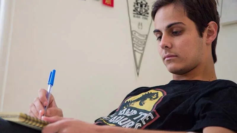 View from below of guy writing in notebook