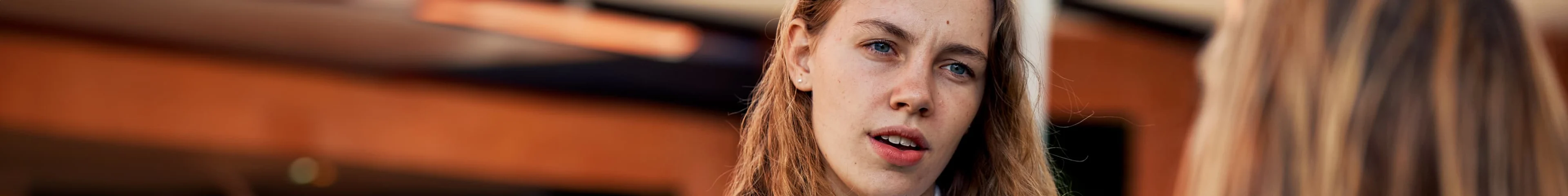 Image of a teen girl talking to her mum. She has a confused expression on her face.