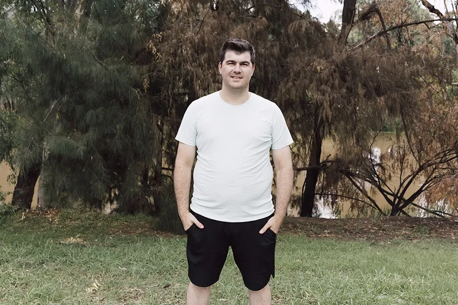 Young man standing in front of river 2