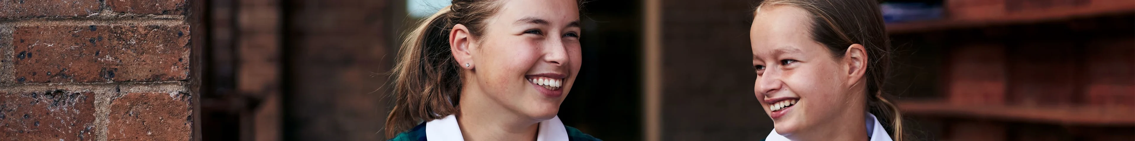 Image of two girls sitting on a step at school.