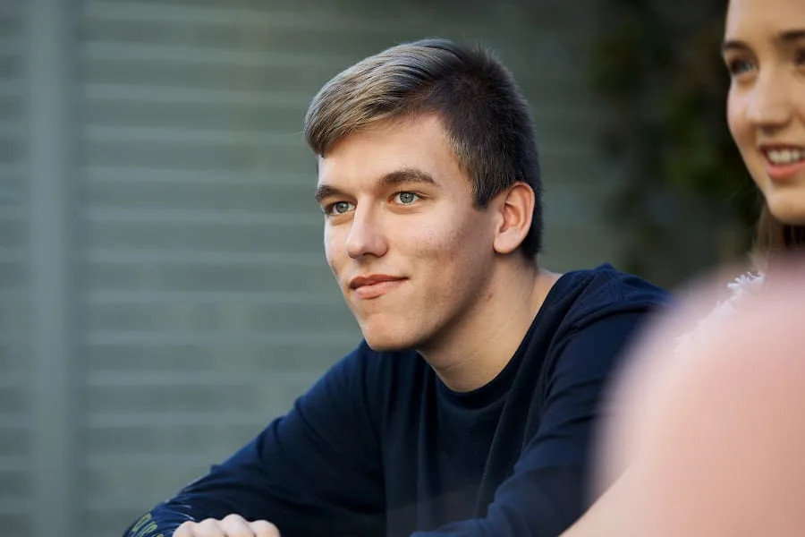 young man sitting down looking off into the distance