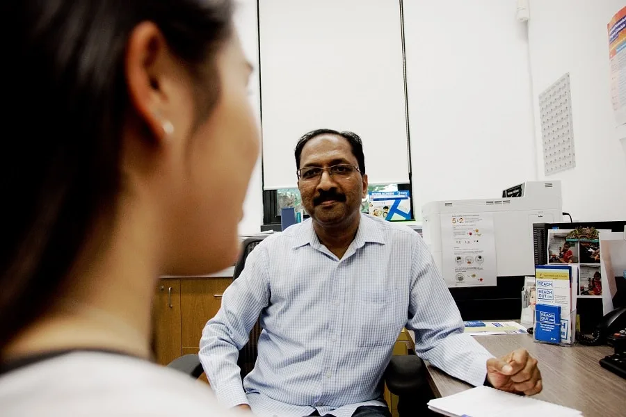 Psychologist talking to young lady in office