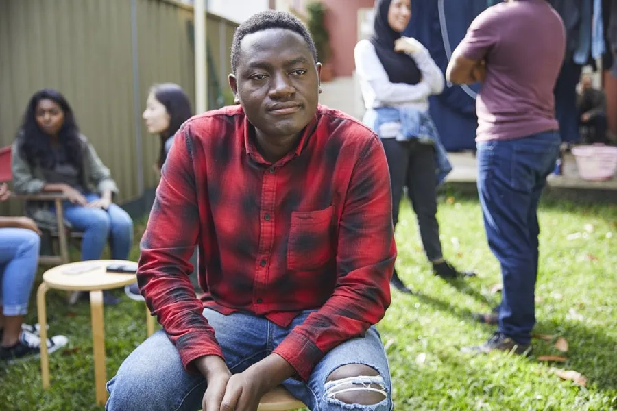 man in red checkered shirt sitting down