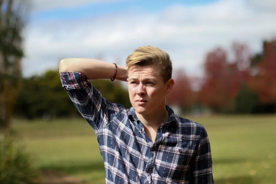 boy in countryside arm on head