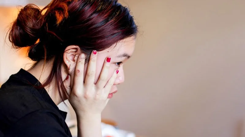 Side view of girl with hand on cheek