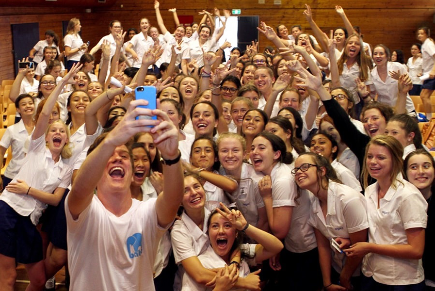 Image of Batyr storyteller taking a selfie with a large group of high school students.