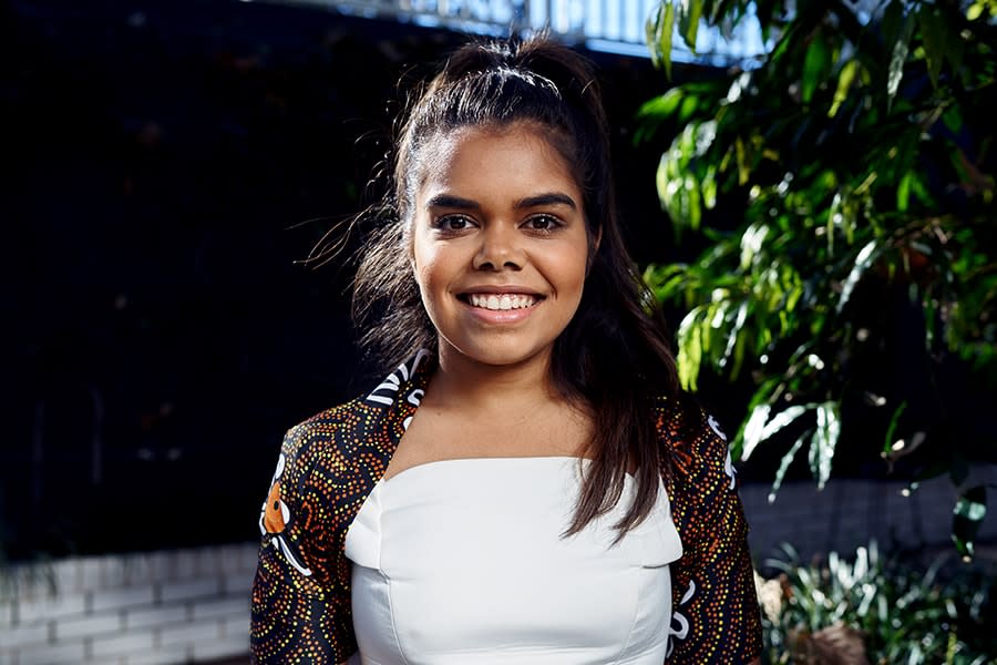 BIanca girl wearing cardigan with traditional Aboriginal art smiling