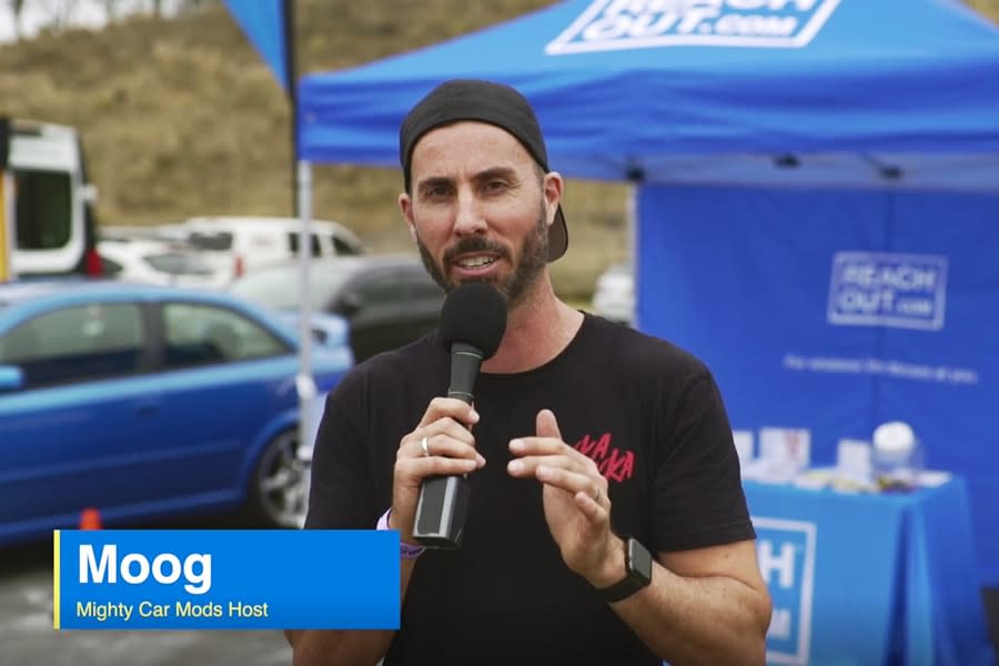 moog mighty car mods host holding microphone talking