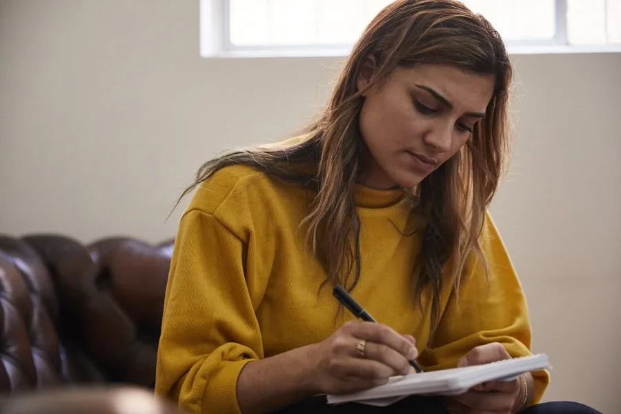 Girl in yellow sweater writing