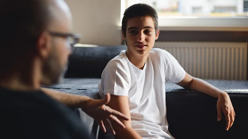 father and son talking on the couch