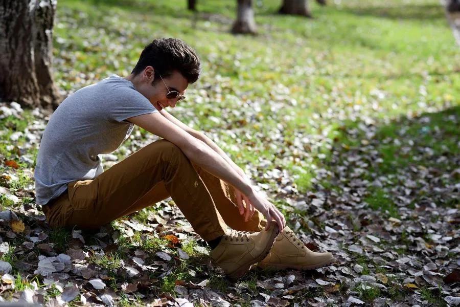 guy sitting on leaves and grass smiling