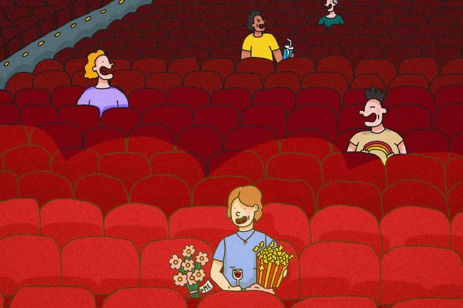 person sitting alone happily in movie theatre thumbnail