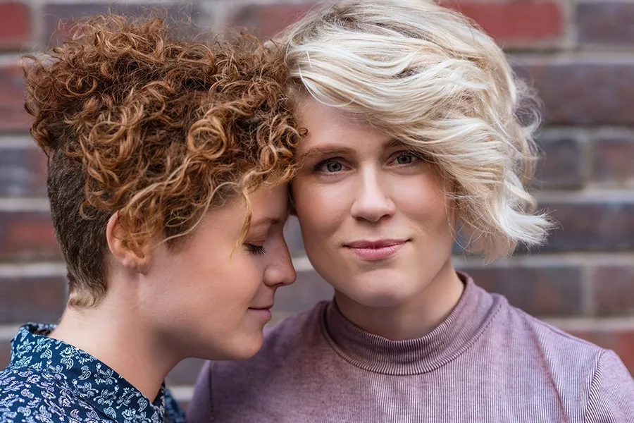 smiling young blonde woman standing with her girlfriend