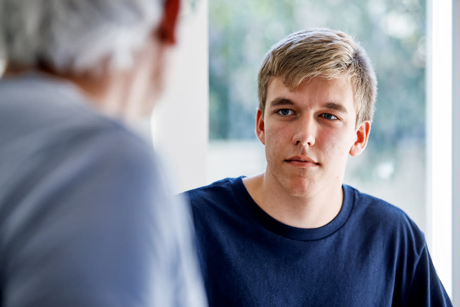 Image of a young man listening to his parent speak.