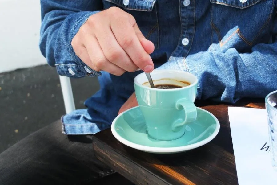 Man stirring coffee at cafe