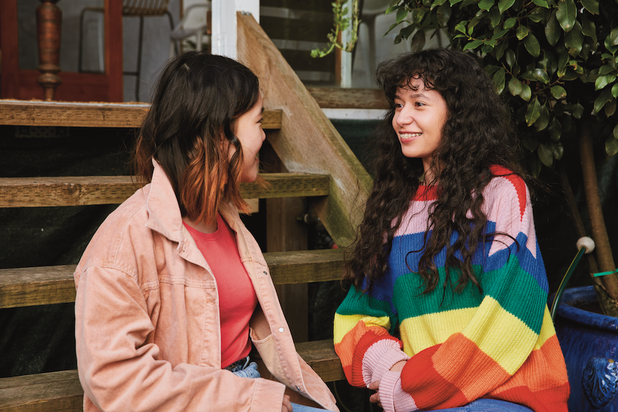 Two young women sitting on stairs outside