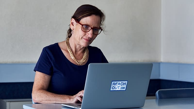 woman wearing glasses looking at laptop