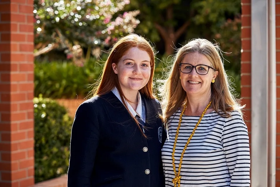 mother with glasses and striped shirt standing with daughter