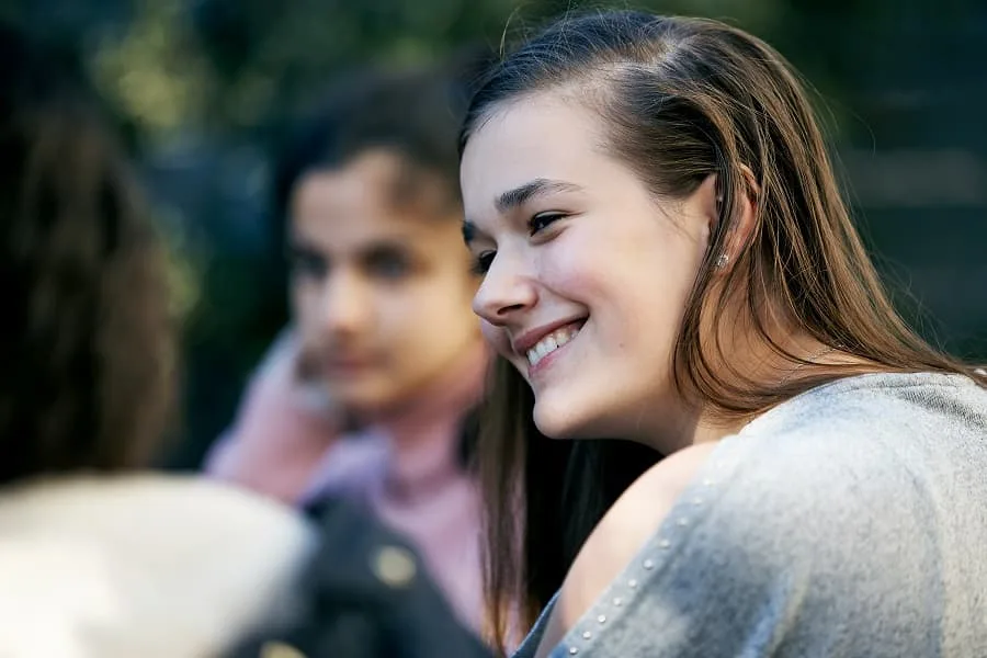 girl sitting with group smiling