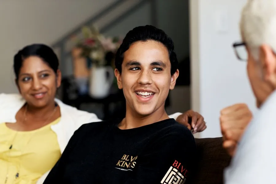 teenage boy smiling with his parents