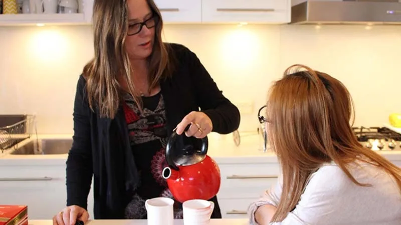 Mother and daughter talking in kitchen